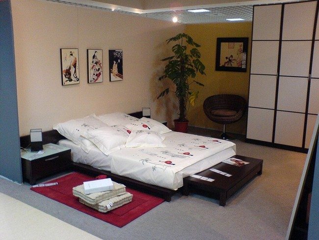 bedroom with shelves and green olive in the corner with japanese pictures on the wall