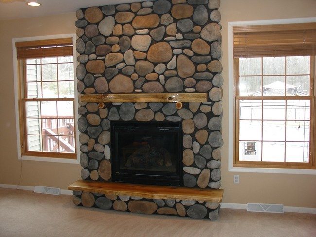 rock fireplace between tow american windows in the light living room