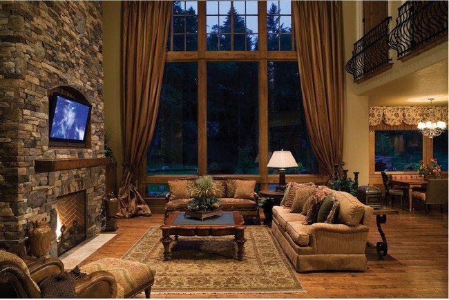 interior rustic modern living room decoration with fireplace combined with tv under it. big wooden broun window with curtains