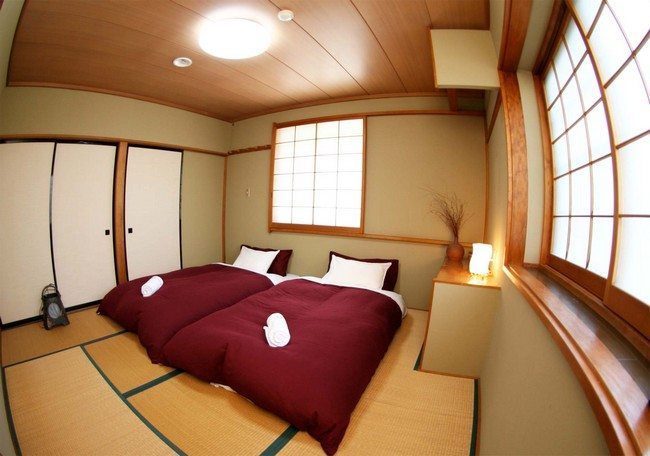 red double bed with white pillows. doors made from bamboo