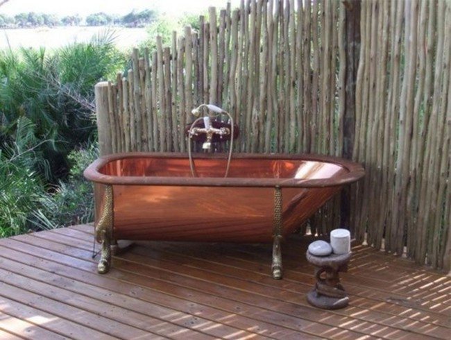 bamboo fence surround the bathroom . brouw red sink on the wooden dloor