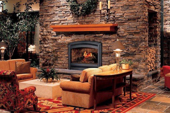 fireplace in the living room? made from stone . surfaced by decorative tile, bright carpet on the floor, three seating sofa. magazine table behind it