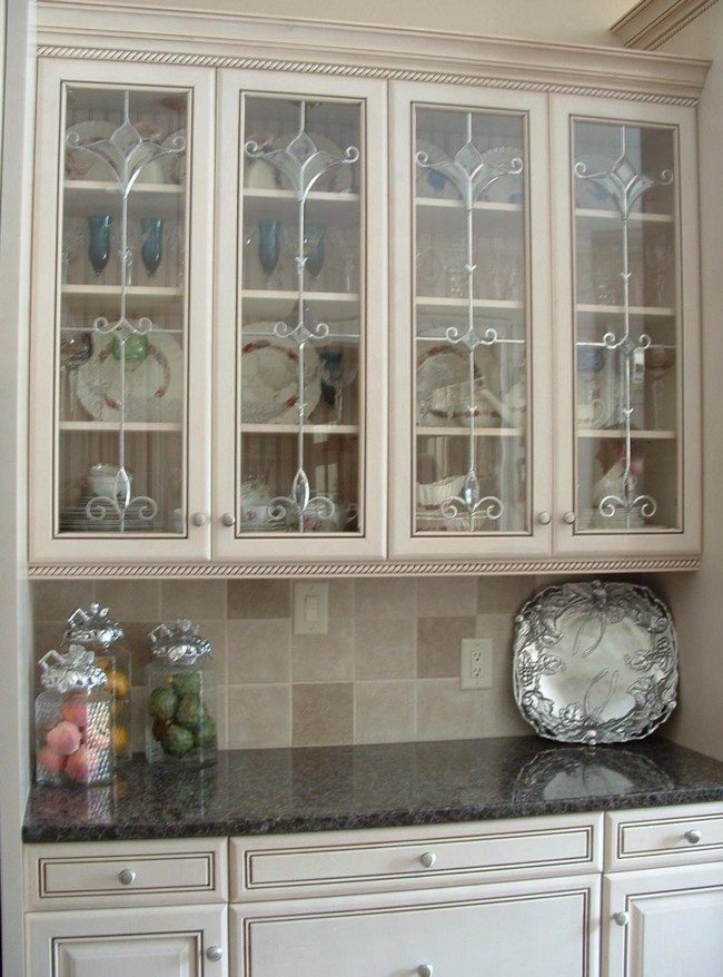 Kitchen with well-patterned regions and shiny, elegant utensils visible through the glass