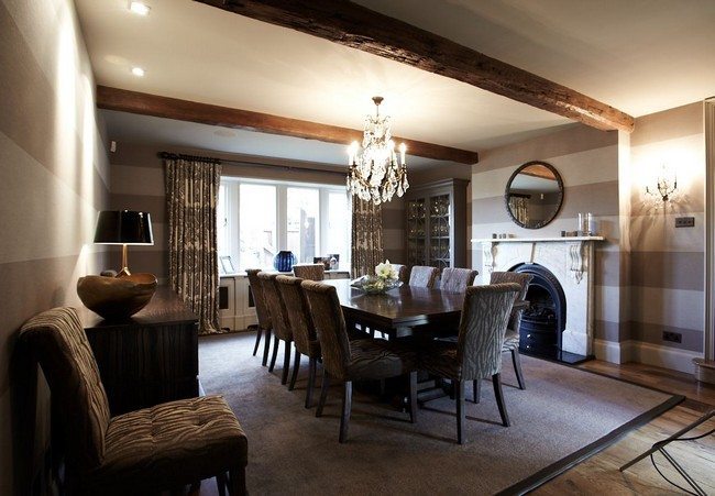 Diing Hall with beams under the ceiling with long blacj table for 8 person, in fron of the fireplace