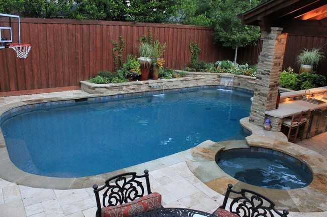 backyard with two pools with the wooden fence behind