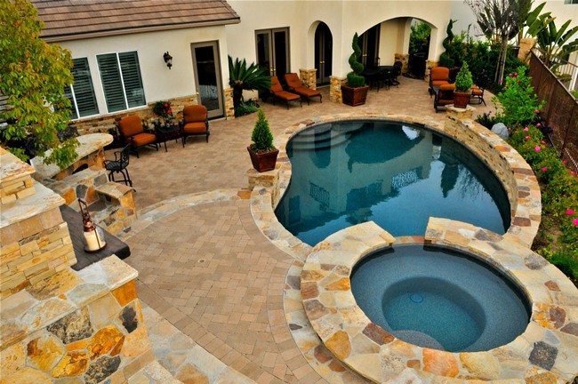 two pools in the backyard covered with the stome tiles