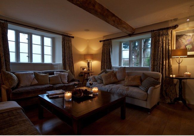 Farm house with wooden beams under the ceiling and two sofat 2 or 3 seater sofas with wooden tea table between them