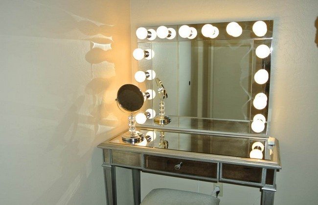 mirrored makeup storagetable with lights around the mirror on the wall