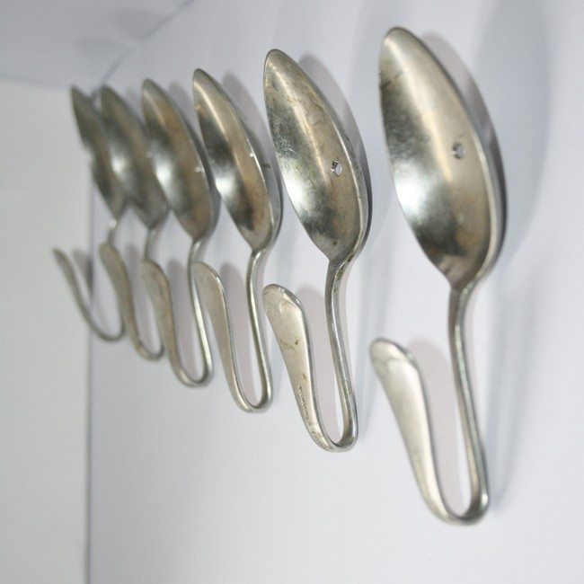 Curved spoons nailed to the wall