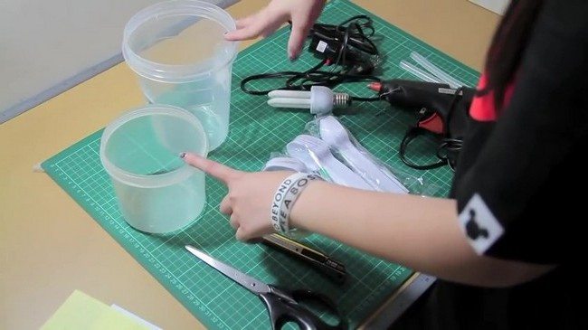 The materials needed to create a DIY lamp from plastic spoon, a glue gun, a bulb, cables and some extra 