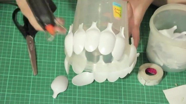 Gluing the white spoonheads to the plastic jar using glue gun