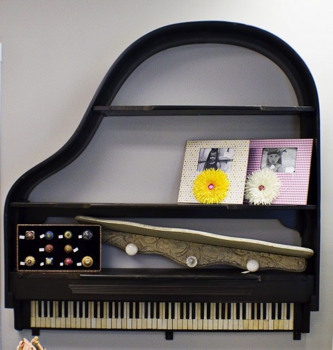 Piano mounted on wall to create a unique bookshelf