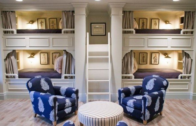 The grey drapes covering the bed area and the upholstered furniture add class and elegance to this bunk room