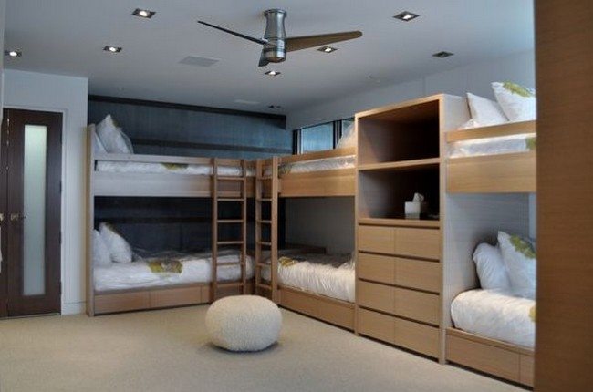 Bunk beds attached to the wall to create space in the center of the room