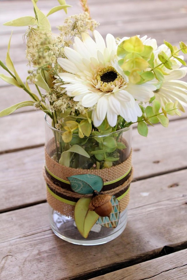 Simple glass vase decorated by wrapping ribbon, rope and flower detail on the exterior