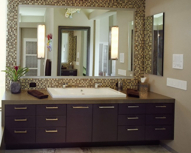 Large mirror placed against mosaic tile wall in earthy hues