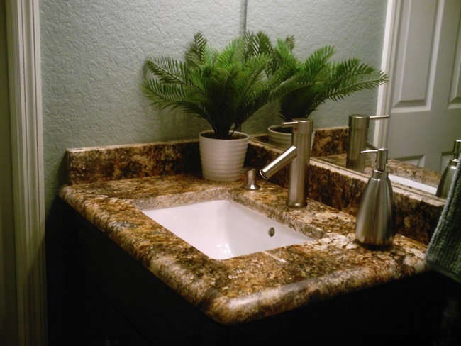 Small brown marble countertop embedded with white marble sink