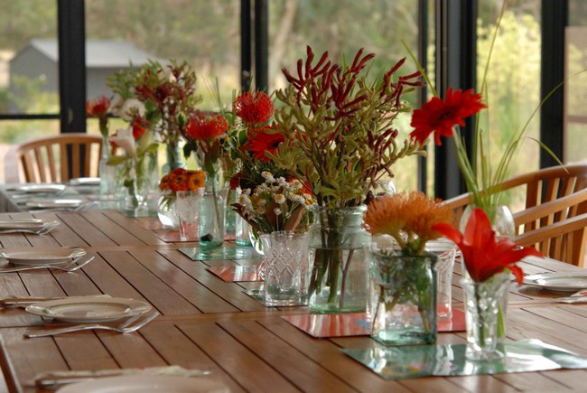 Row of water-filled glass vases immersed with flowers