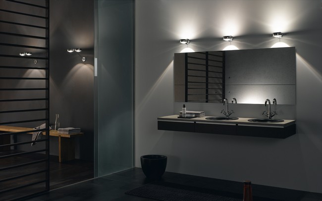 Dimly-lit bathroom with illuminating lights above the mirror