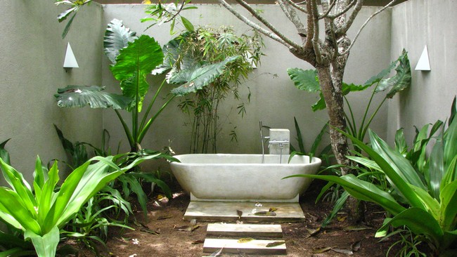 Outdoor bathtub in the corner of the garden, with white terrace steps