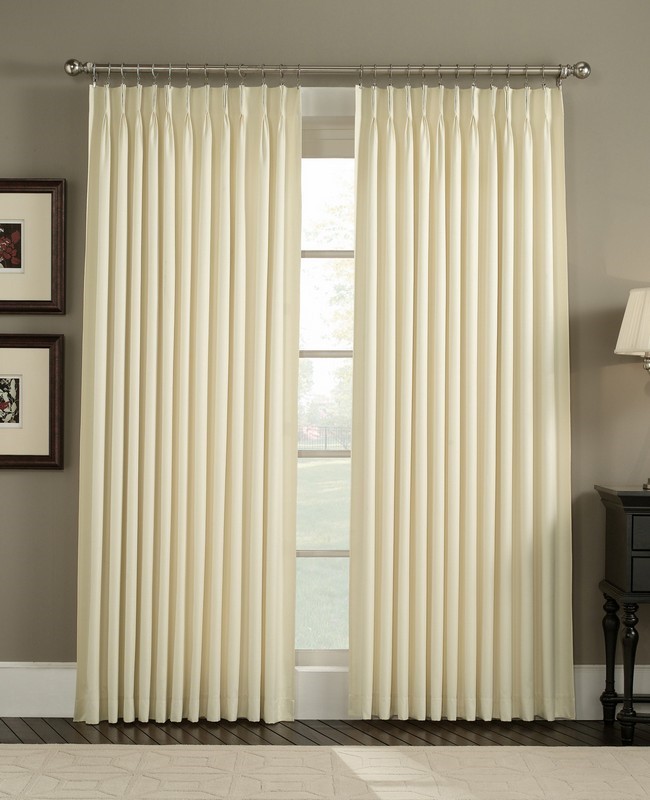 Ivory curtains with elegant design on a metallic holder against light grey walls
