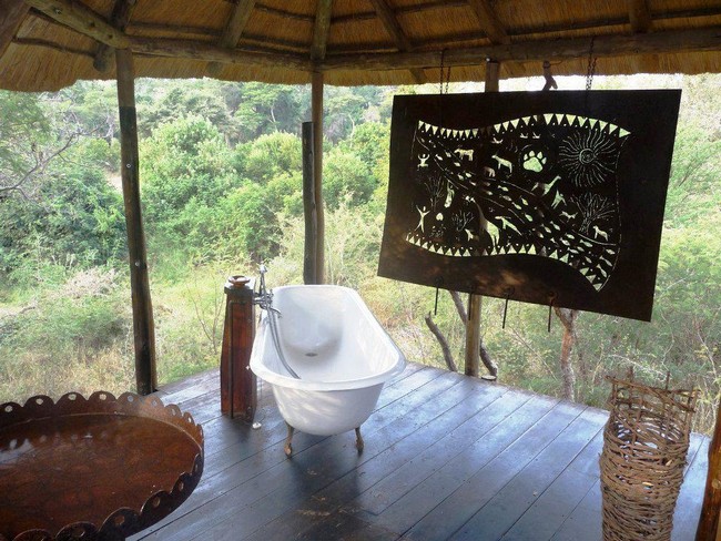 Bathroom with an art piece in the middle of a lush forest