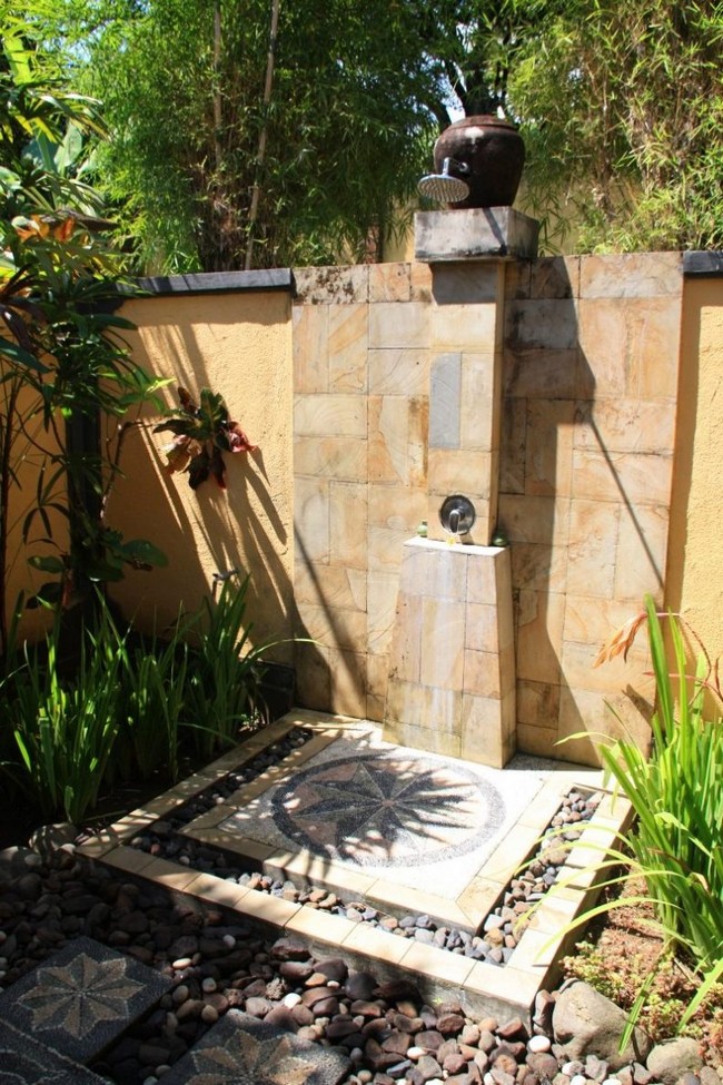 Stand-alone outdoor shower with plenty of small rocks