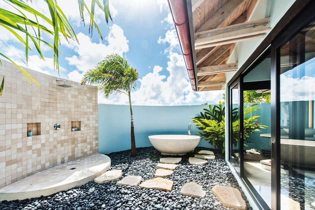 Tropical-style bathroom with tiles, stone and blue wall