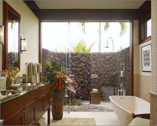 Indoor bathroom that extends into outdoor bathroom with stone wall