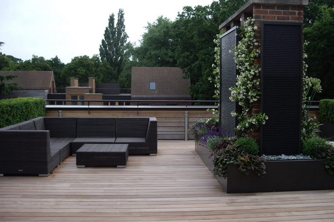 Terrace with grey couch and coffee table set and a flower arrangement in the center