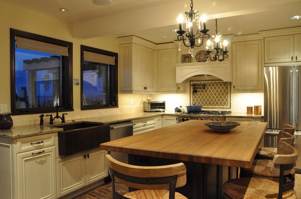 Simple wrought iron chandeliers that match the wrought iron finishes of the furniture throughout the kitchen