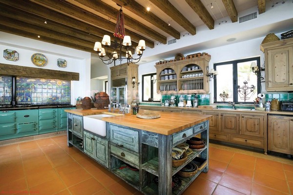 Bluish-green cabinets and tile backsplash that adds color and exuberance to the otherwise dull Spanish style kitchen