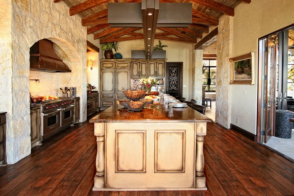 Spanish-style kitchen with high ceiling with wooden and metal beams