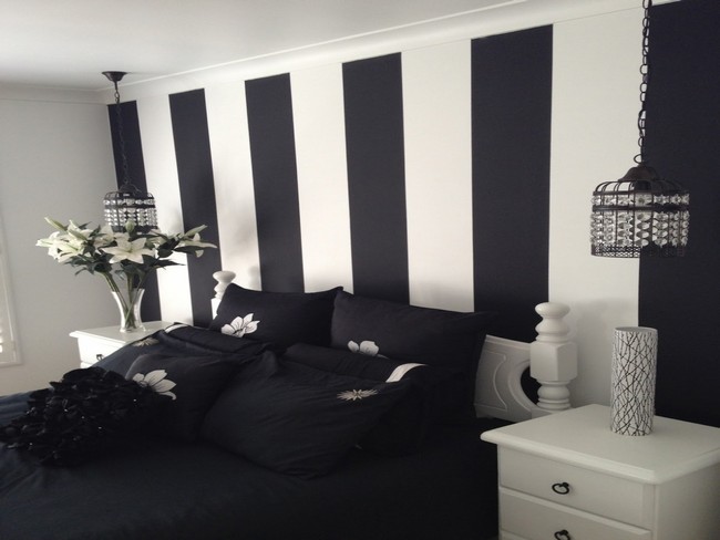 Black stripes on white wall add a bold look to this black and white bedroom