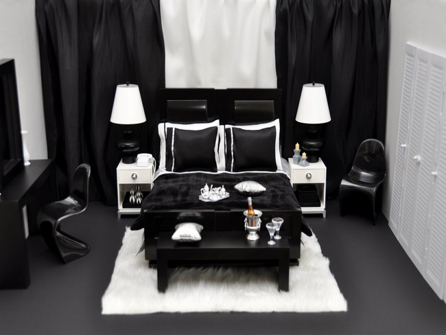 Small bedroom with heavy black drapes and white rug