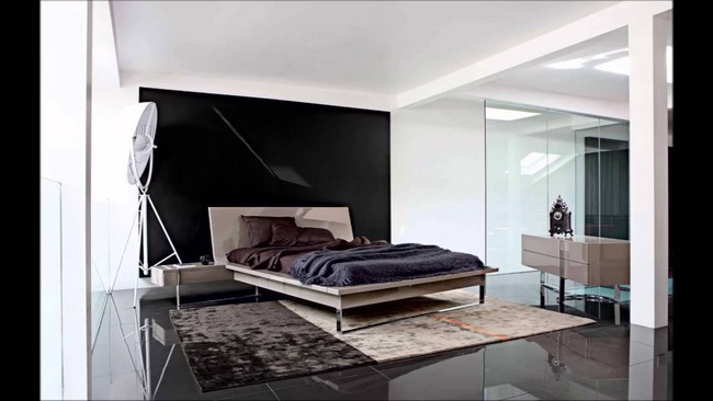 Black and white bedroom with a shiny, black stone floor and neutral décor pieces