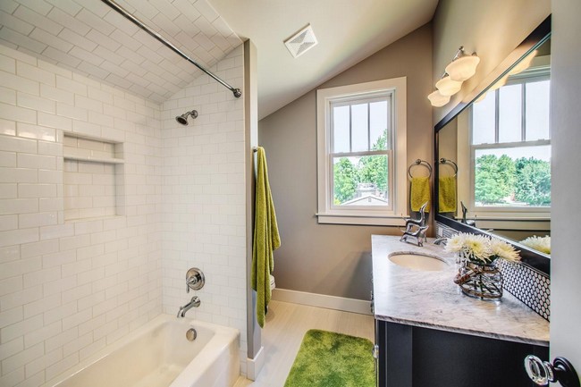 Slanted ceiling that merges with wall, made with white subway tile, making the bathroom stand out