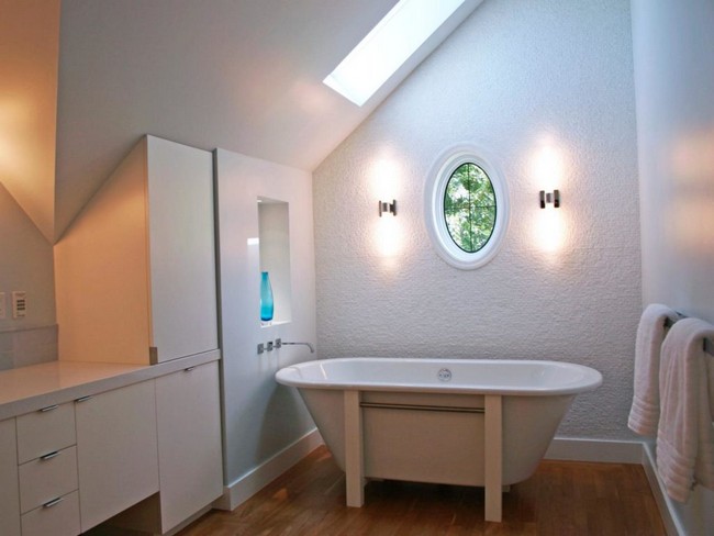 Recessed lighting in this bathroom has the outcome of nullifying the effect of the slanted ceiling, by making the bathroom appear larger