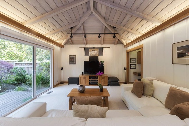 Slightly slanted hardwood ceiling with beams, inducing a rustic charm