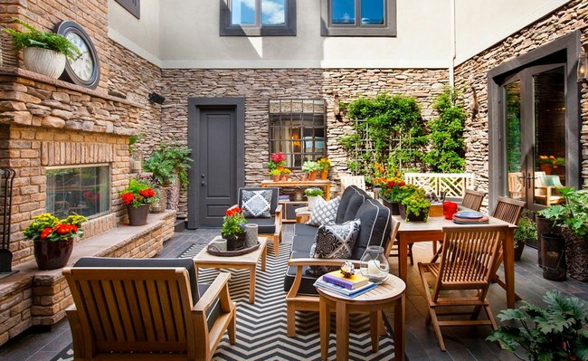 Bright and lively stone terrace with plenty of flowers and décor elements