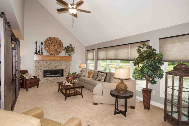 Stone fireplace adds warmth to living room with slanted ceiling