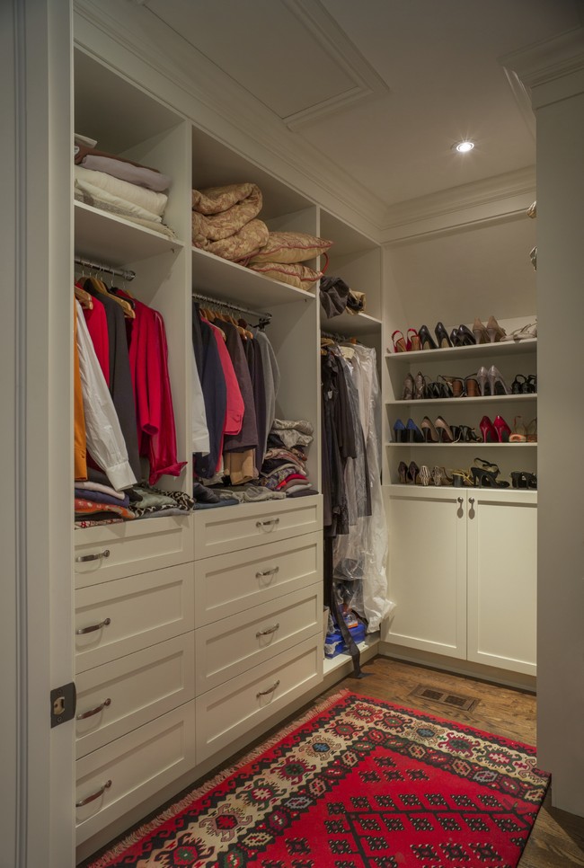 Large walk-in-closet decorated with a red, patterned rug