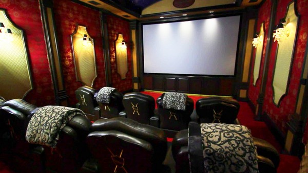 Lively and dazzling home theater design with red patterned wallpaper