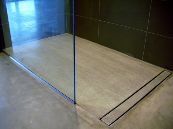 Small walk-in shower with tile wall and glass closure