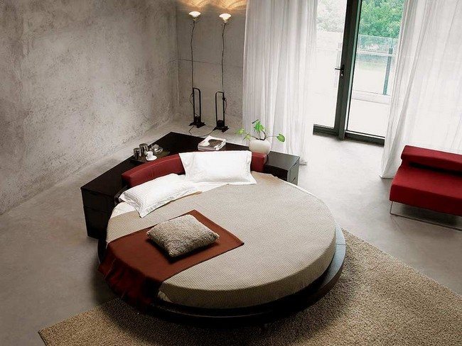 Black, circular bed surrounded by a black cabinet